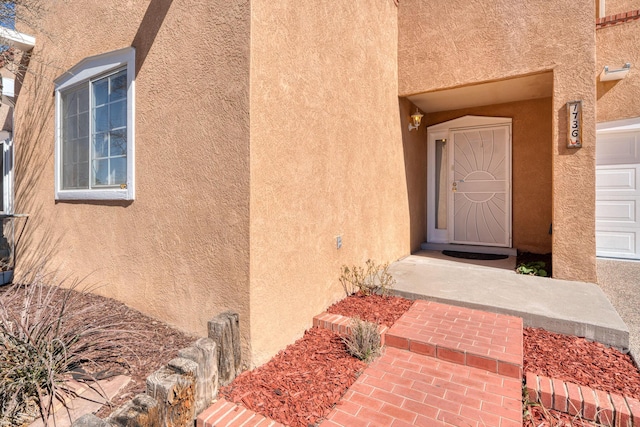 doorway to property featuring stucco siding