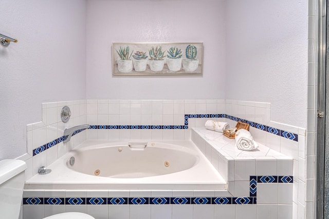 full bath with toilet, a textured wall, and a whirlpool tub