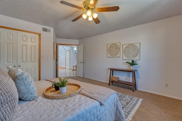 bedroom with a textured ceiling, visible vents, baseboards, a ceiling fan, and carpet