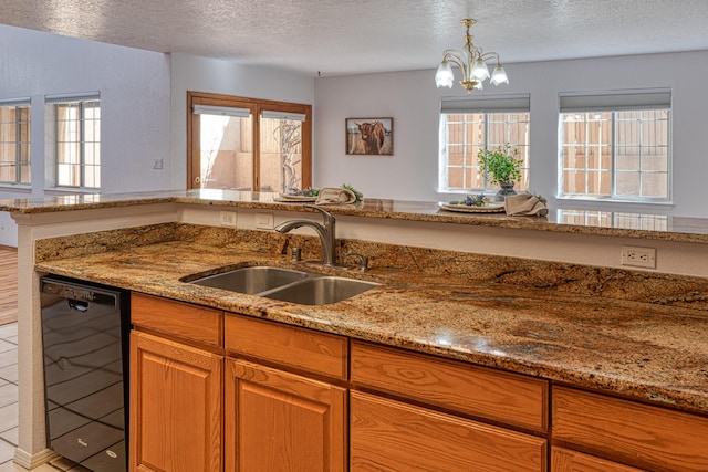 kitchen with black dishwasher, light stone counters, a textured ceiling, and a sink