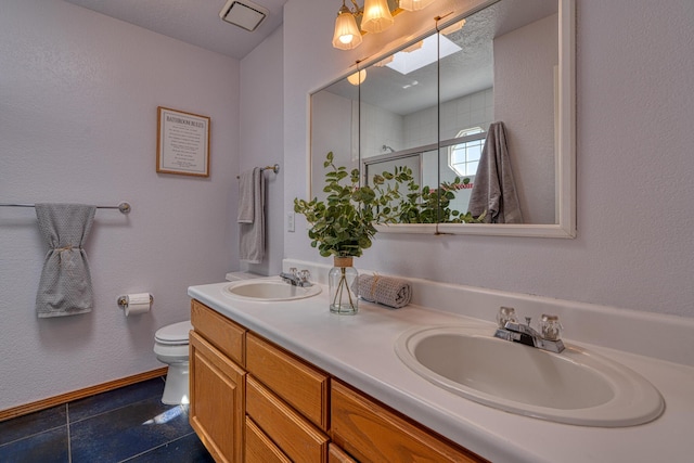 full bath with toilet, a skylight, a shower stall, and a sink