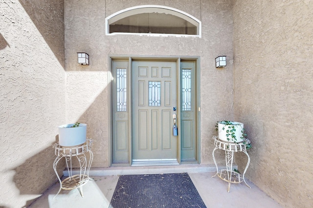 view of exterior entry featuring stucco siding