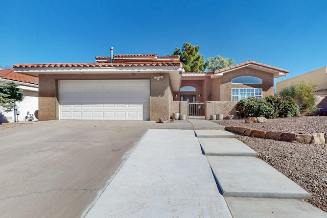 view of front facade featuring a garage, driveway, a gate, and stucco siding