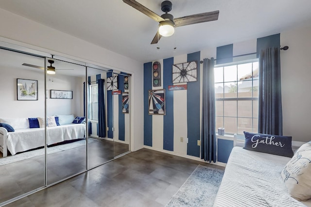 bedroom with finished concrete floors, a closet, baseboards, and a ceiling fan