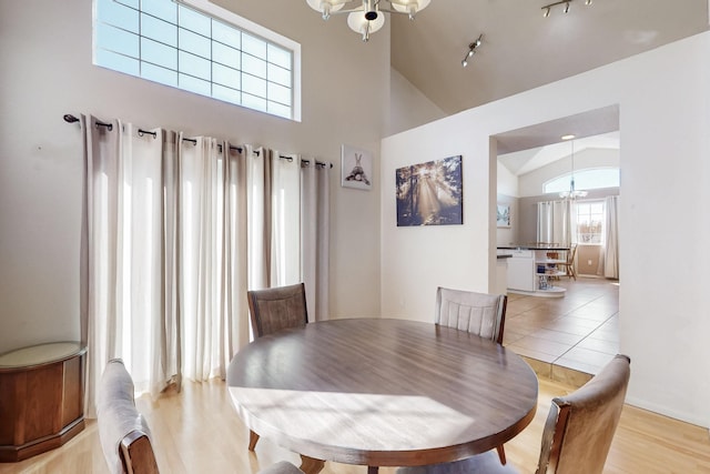 dining area featuring a chandelier, high vaulted ceiling, and light tile patterned floors