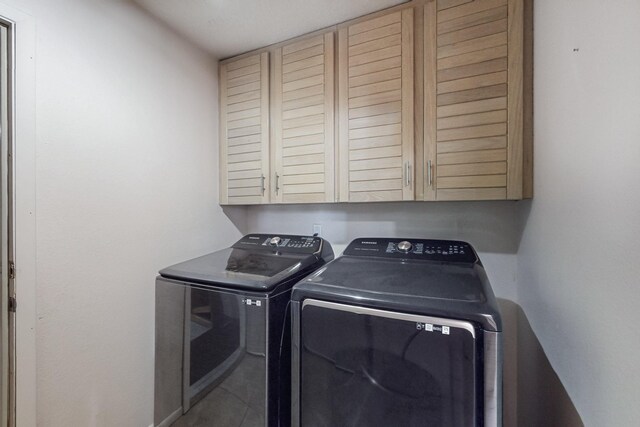 washroom with separate washer and dryer and cabinet space