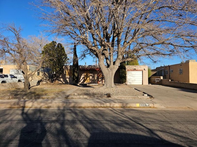 southwest-style home with driveway, an attached garage, and stucco siding