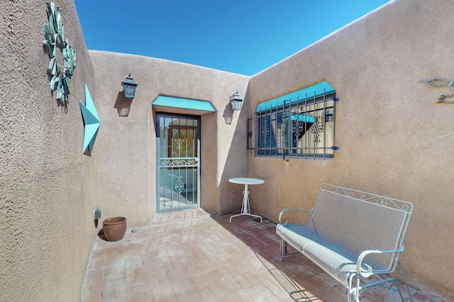 entrance to property featuring a patio and stucco siding