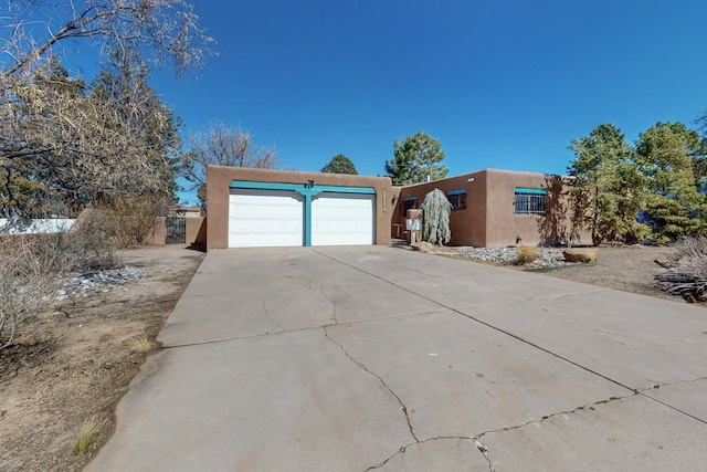 view of front of property with concrete driveway, an attached garage, and stucco siding