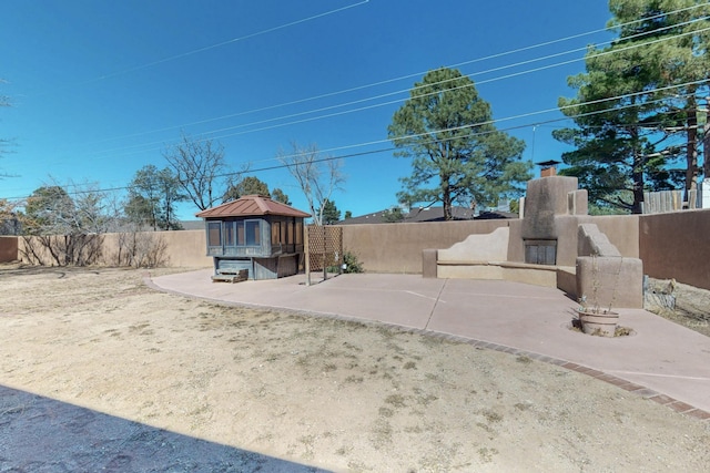 view of yard with a patio, a fireplace, and a fenced backyard