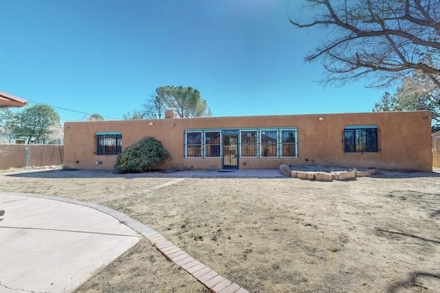 rear view of property with fence and stucco siding