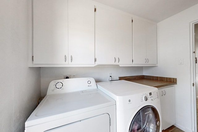 washroom with cabinet space and washer and dryer