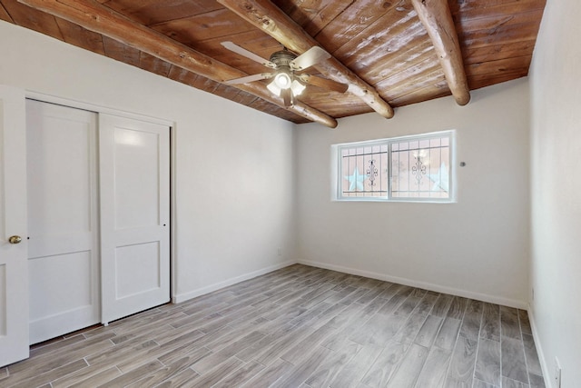 unfurnished bedroom featuring beamed ceiling, wooden ceiling, and light wood-style floors