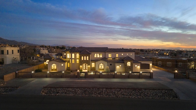 view of front of home with curved driveway, fence private yard, and a residential view