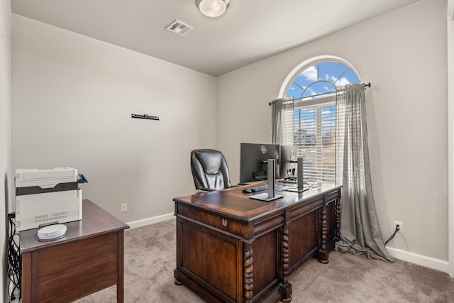 office space featuring light carpet, visible vents, and baseboards