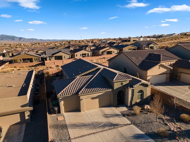 view of front of property with a garage, a tile roof, a residential view, and stucco siding