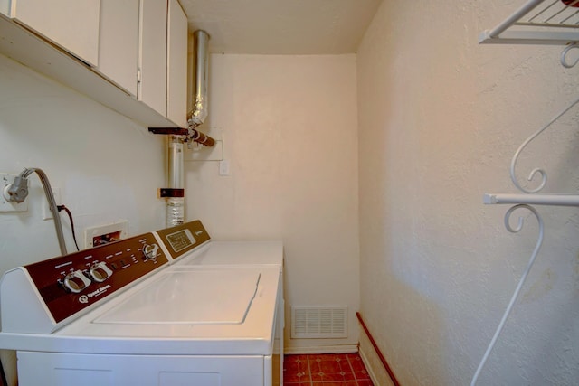 laundry room featuring washer and dryer, cabinet space, visible vents, and baseboards