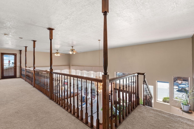 hall with carpet floors and a textured ceiling