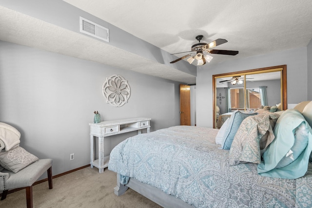 carpeted bedroom with baseboards, visible vents, ceiling fan, a textured ceiling, and a closet