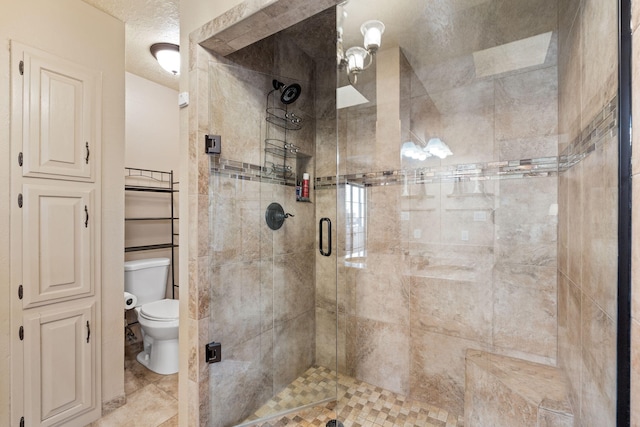 bathroom with a textured ceiling, a shower stall, and toilet