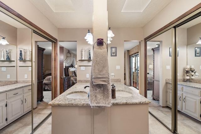 ensuite bathroom with a sink, double vanity, and connected bathroom