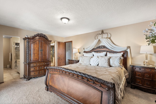 bedroom with light colored carpet, a textured ceiling, and ensuite bathroom