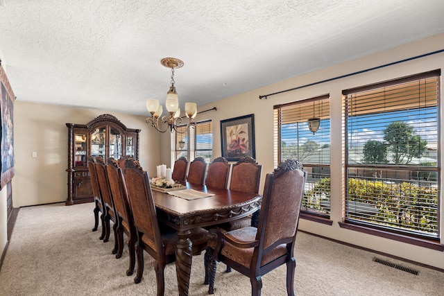 dining space with light colored carpet, visible vents, baseboards, and an inviting chandelier