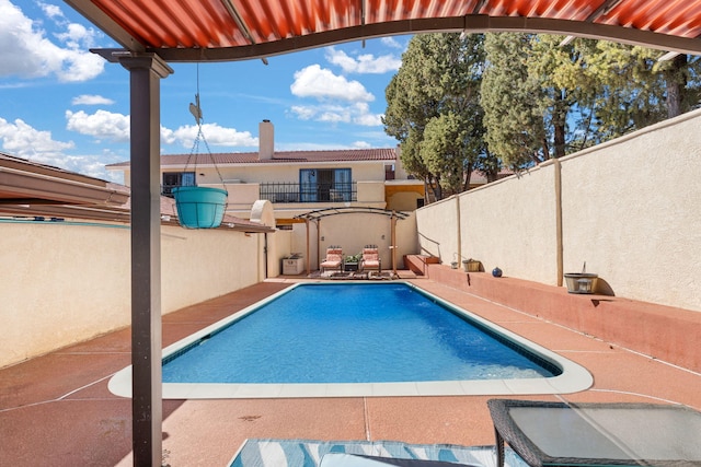 outdoor pool featuring a patio area and fence