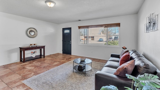 living area featuring baseboards and a textured ceiling