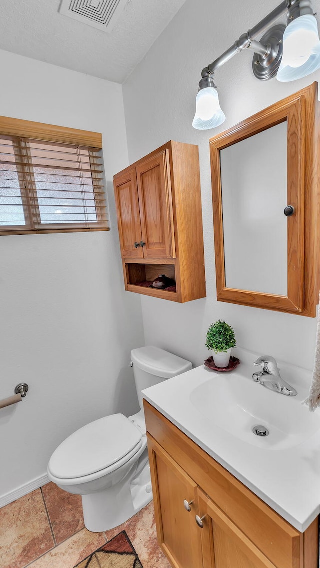 bathroom featuring baseboards, visible vents, vanity, and toilet