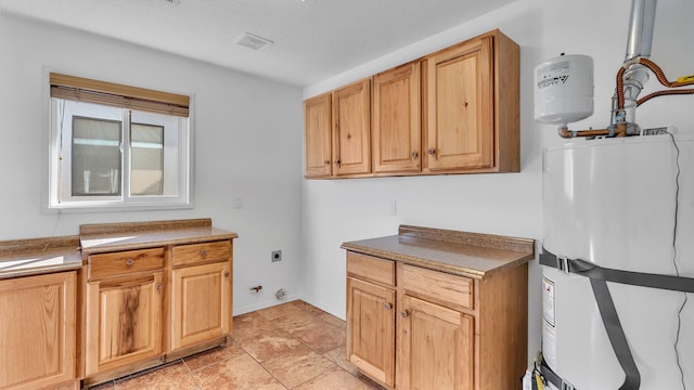 laundry area with cabinet space, baseboards, visible vents, hookup for an electric dryer, and water heater