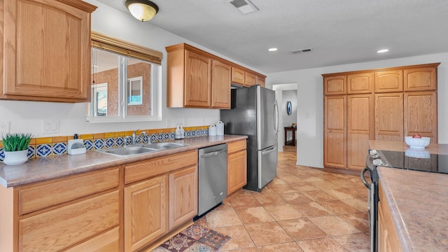 kitchen featuring stainless steel appliances, a sink, visible vents, and recessed lighting