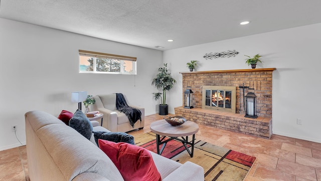 living area featuring a brick fireplace, baseboards, a textured ceiling, and recessed lighting