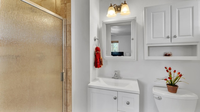 bathroom with vanity, a shower stall, and toilet