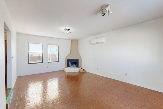 unfurnished living room with a wall unit AC and brick floor