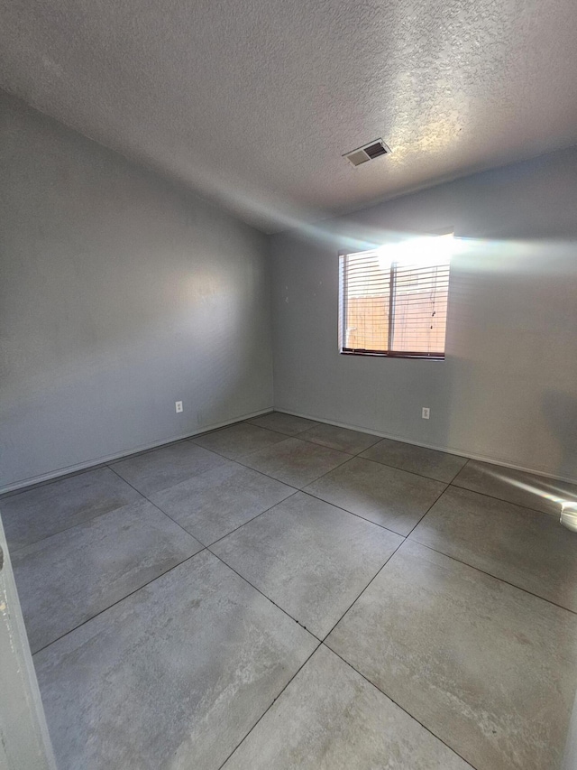 unfurnished room with a textured ceiling and visible vents