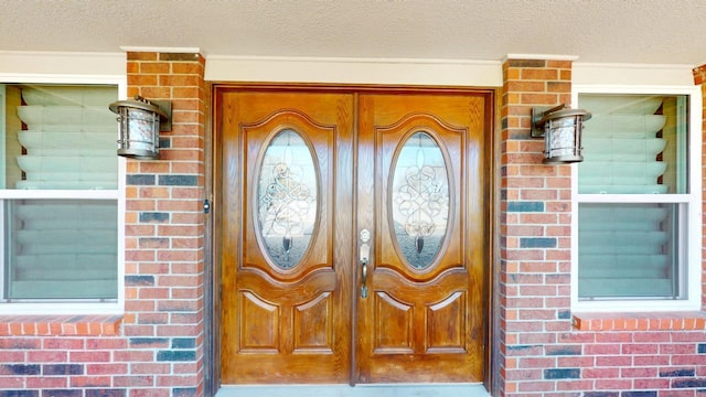 property entrance featuring a garage and brick siding