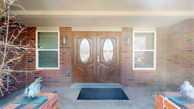 property entrance featuring brick siding