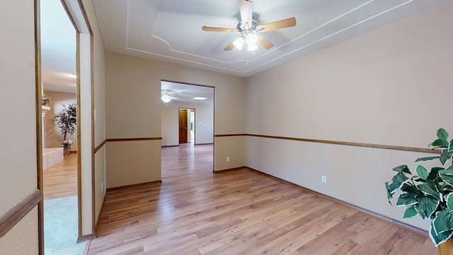 empty room with ceiling fan and light wood finished floors