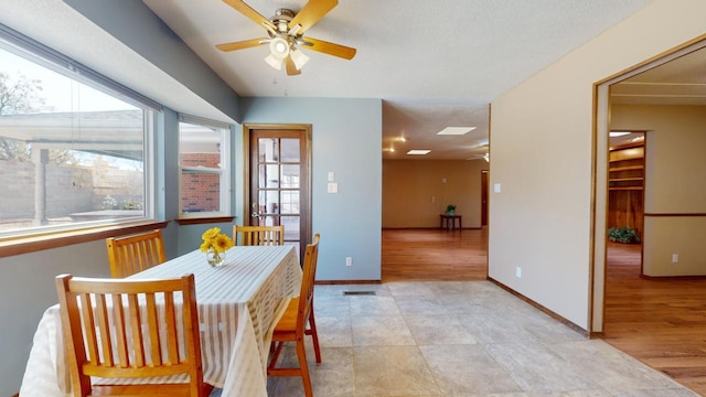 dining area featuring a ceiling fan, light wood-style floors, and baseboards