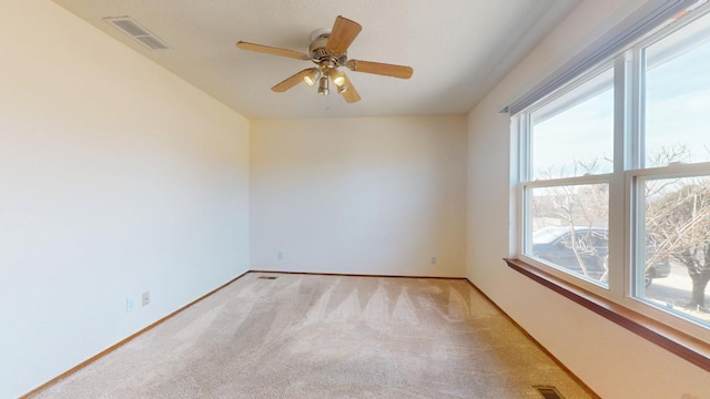 empty room with light carpet, baseboards, visible vents, and ceiling fan