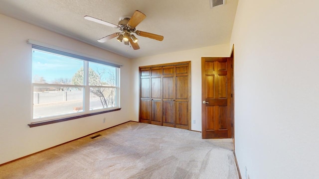 unfurnished bedroom featuring carpet floors, a closet, visible vents, and baseboards