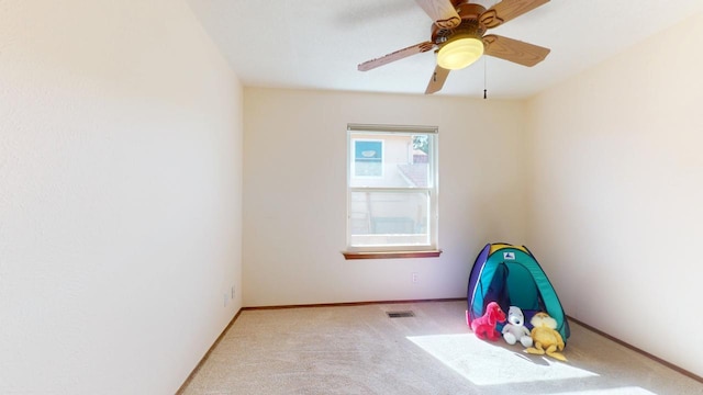 interior space with carpet floors, visible vents, baseboards, and a ceiling fan