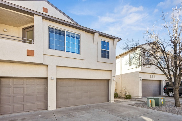 view of front facade featuring a garage, driveway, and stucco siding