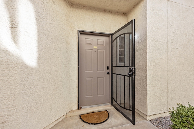 doorway to property featuring stucco siding