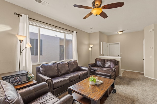 carpeted living area featuring baseboards, visible vents, and a ceiling fan