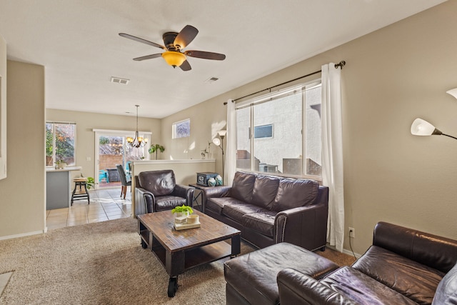 living area featuring light carpet, visible vents, baseboards, and ceiling fan with notable chandelier