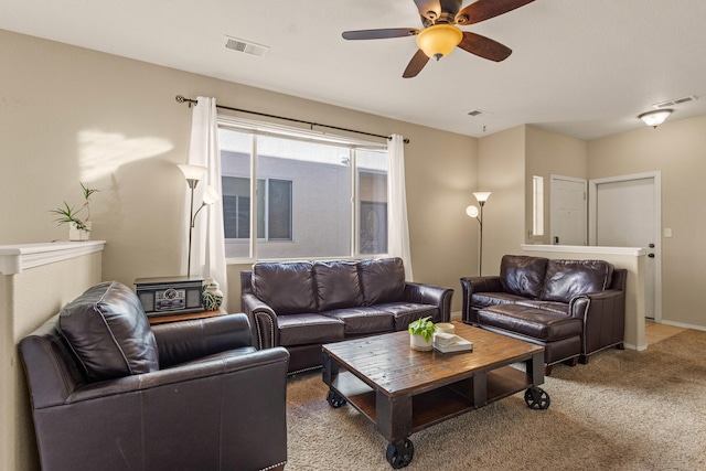 living area with ceiling fan, visible vents, baseboards, and light colored carpet