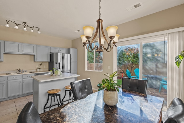 dining area with visible vents, a notable chandelier, and light tile patterned floors