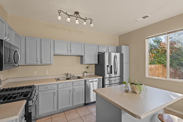 kitchen with a sink, visible vents, light countertops, appliances with stainless steel finishes, and gray cabinets